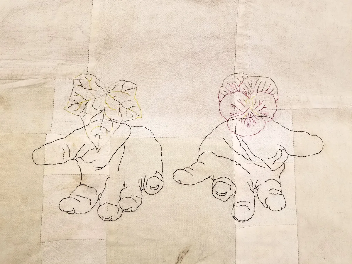 Offering — dishcloths with two embroidered hands holding leaves and flowers